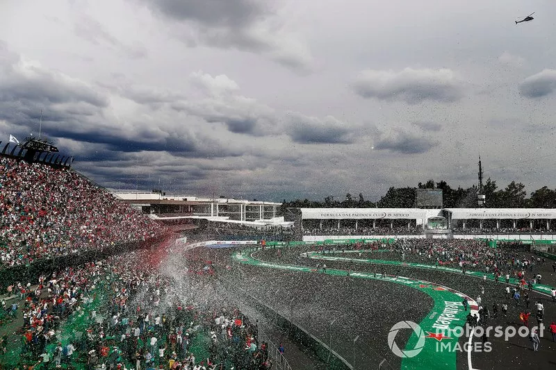 Los aficionados invaden la pista en el podio después de la carrera