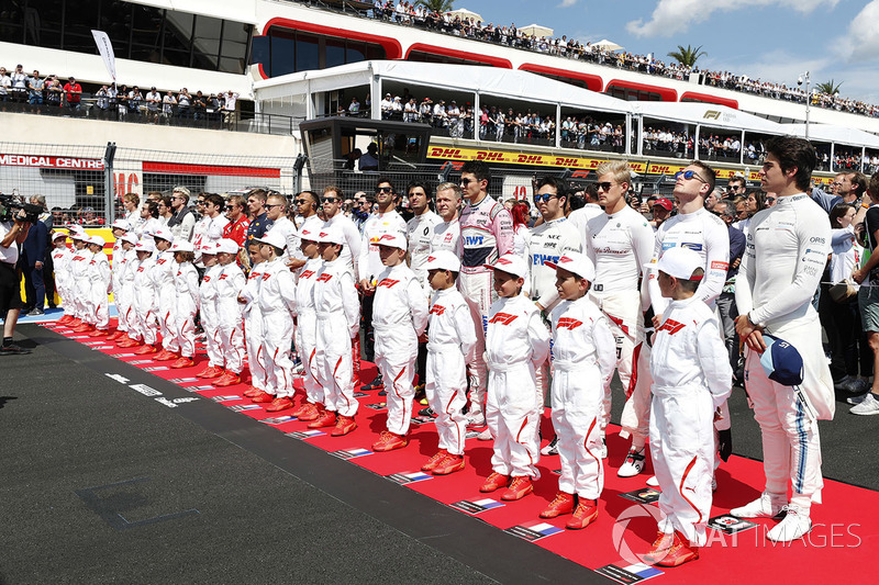 Les pilotes et les Grid Kids écoutent la Marseillaise