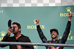 Podio: el actor Gerard Butler toma de la bota de Daniel Ricciardo, Red Bull Racing el tercer lugar