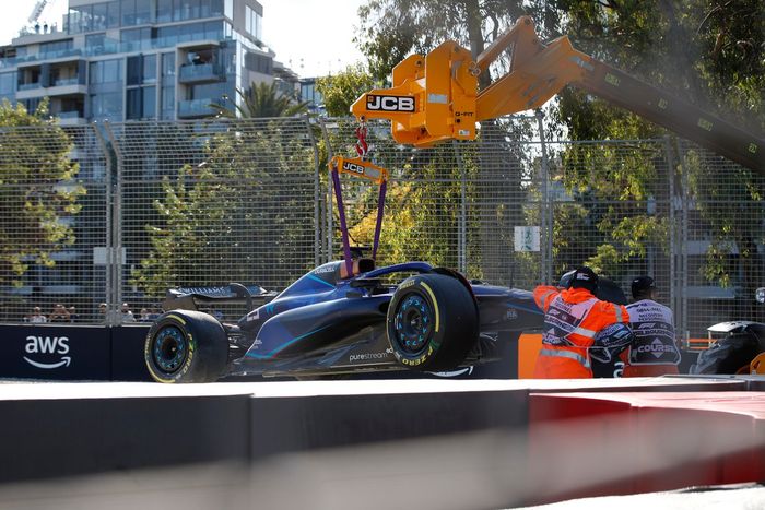 Oficiales de pista retiran del circuito el coche dañado de Alex Albon, Williams FW45