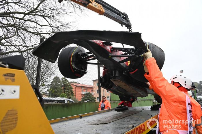 Oficiales de pista cargan el coche de Carlos Sainz Jr., Ferrari F1-75, en una grúa