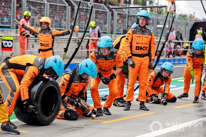 Los miembros del equipo de boxes de McLaren se colocan en posición para una parada