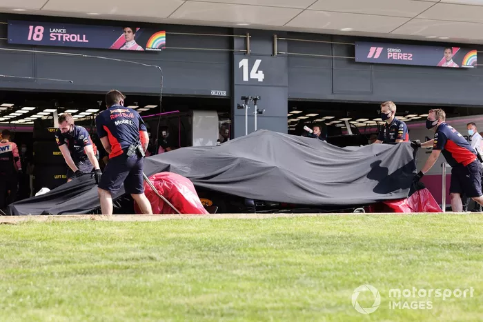 Los mecánicos de Red Bull con el monoplaza dañado de Alex Albon, Red Bull Racing RB16 en el garaje bajo una lona después de su accidente en la FP2