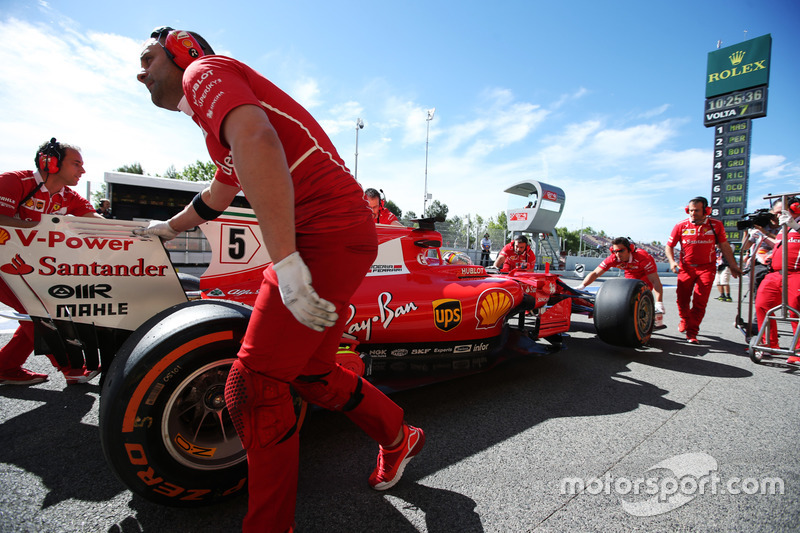 Ferrari engineers assist Sebastian Vettel, Ferrari SF70H, in the pit lane