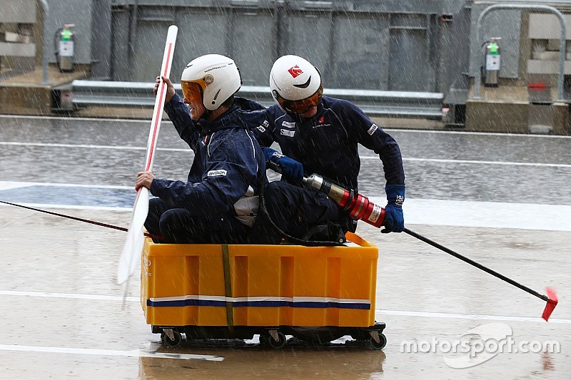 Sauber F1 Team mechanics practice their boating skills in the wet pit lane