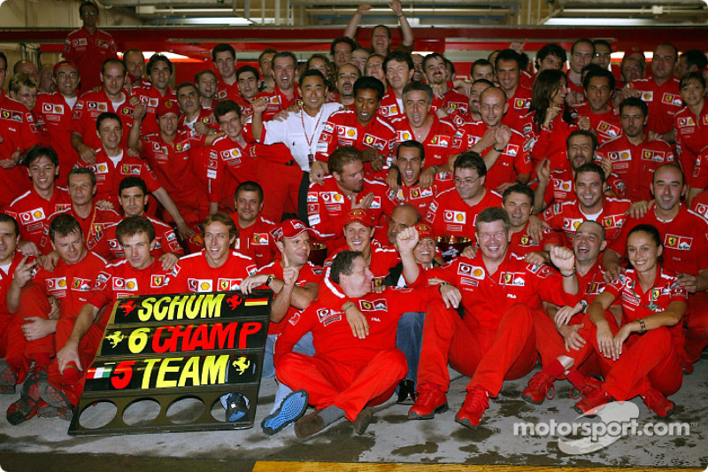 Michael Schumacher y Rubens Barrichello celebran con los miembros del equipo Ferrari