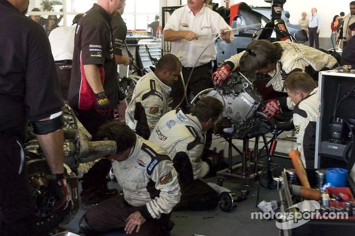 Los miembros del equipo Minardi Team USA reemplazan el embrague en el coche de Robert Doornbos