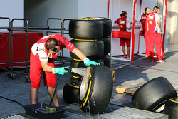 Un mecánico de Ferrari limpia las llantas Pirelli