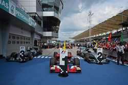 De Ferrari SF15-T van racewinnaar Sebastian Vettel, Ferrari, in parc ferme, geflankeerd door de Merc