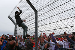 Lewis Hamilton, Mercedes AMG F1 climbs hte fence to greet the fans