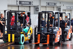 Mecânicos da Lotus F1 Team com empilhadeira no paddock