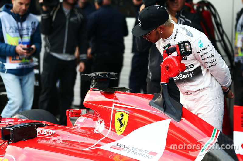 Lewis Hamilton, Mercedes AMG F1 looks at the Ferrari SF15-T of Sebastian Vettel, Ferrari in parc fer