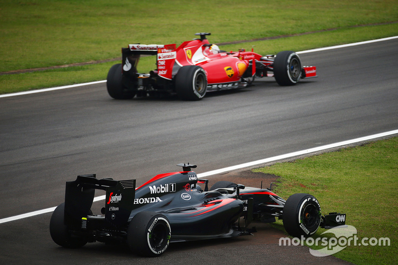 El McLaren MP4-30 de Fernando Alonso, McLaren  pasa por Sebastian Vettel, Ferrari en la segunda sesi