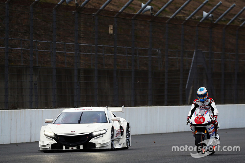 Fernando Alonso conta una motocicleta Honda con el Honda NSX