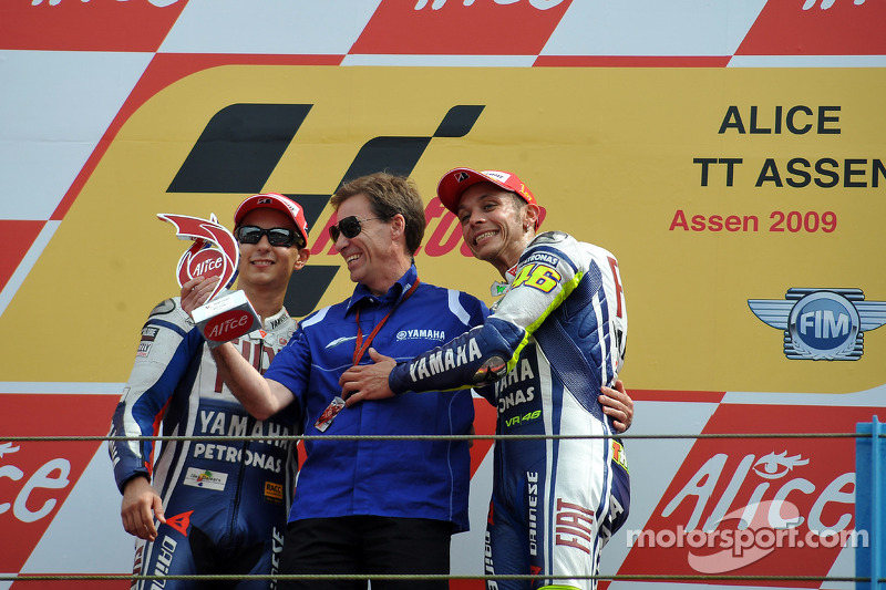 2009 Rossi celebra su victoria número 100 con Lin Jarvis y Jorge Lorenzo en el podio